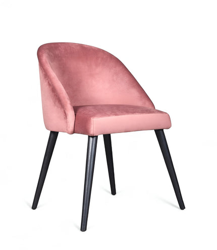 Side view of the Vaya Home Alveare dining chair with pink upholstery and black tapered legs.