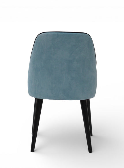 Back view of the Vaya Home Alven dining chair with a softly curved blue upholstered backrest and black legs.