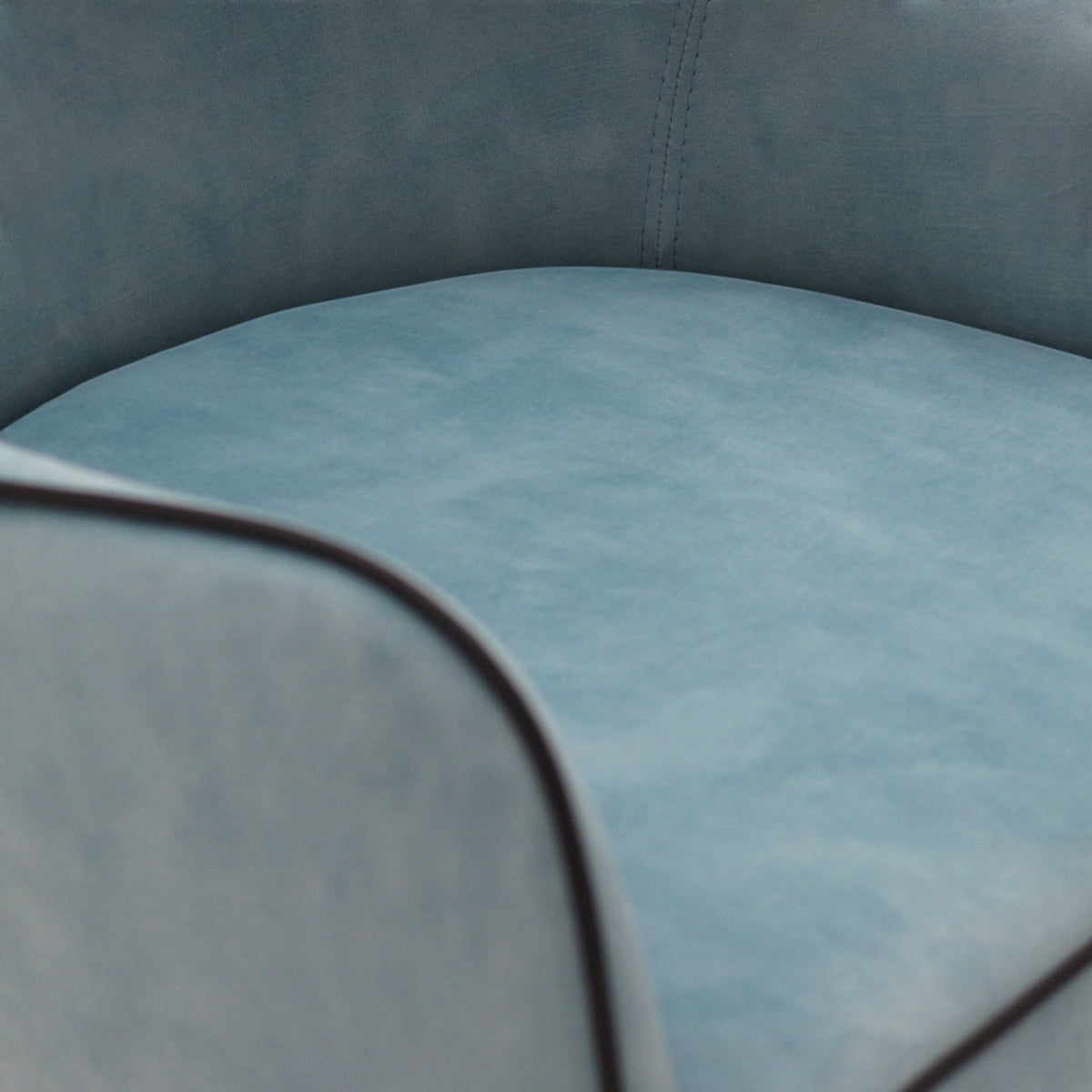 Close-up of the Vaya Home Alven dining chair showing blue upholstery, piped edge detailing, and seat texture.