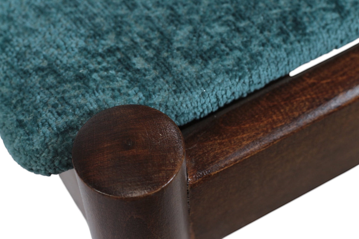 Close-up of the Vaya Home Angolo dining chair showing blue upholstery and dark wood frame detail.