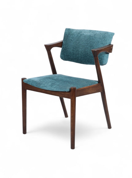 Front angled view of the Vaya Home Angolo dining chair with blue upholstery, angled wood arms, and a dark wood frame.