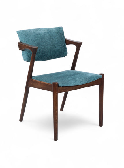 Front angled view of the Vaya Home Angolo dining chair with blue upholstery, angled wood arms, and a dark wood frame.
