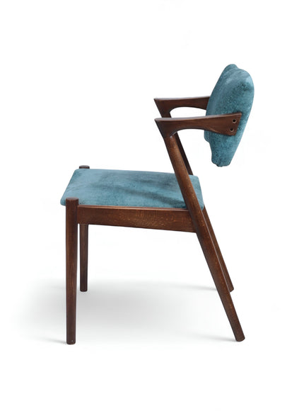 Product view of the Vaya Home Angolo dining chair in blue upholstery with angled wood arms and a dark wood frame.