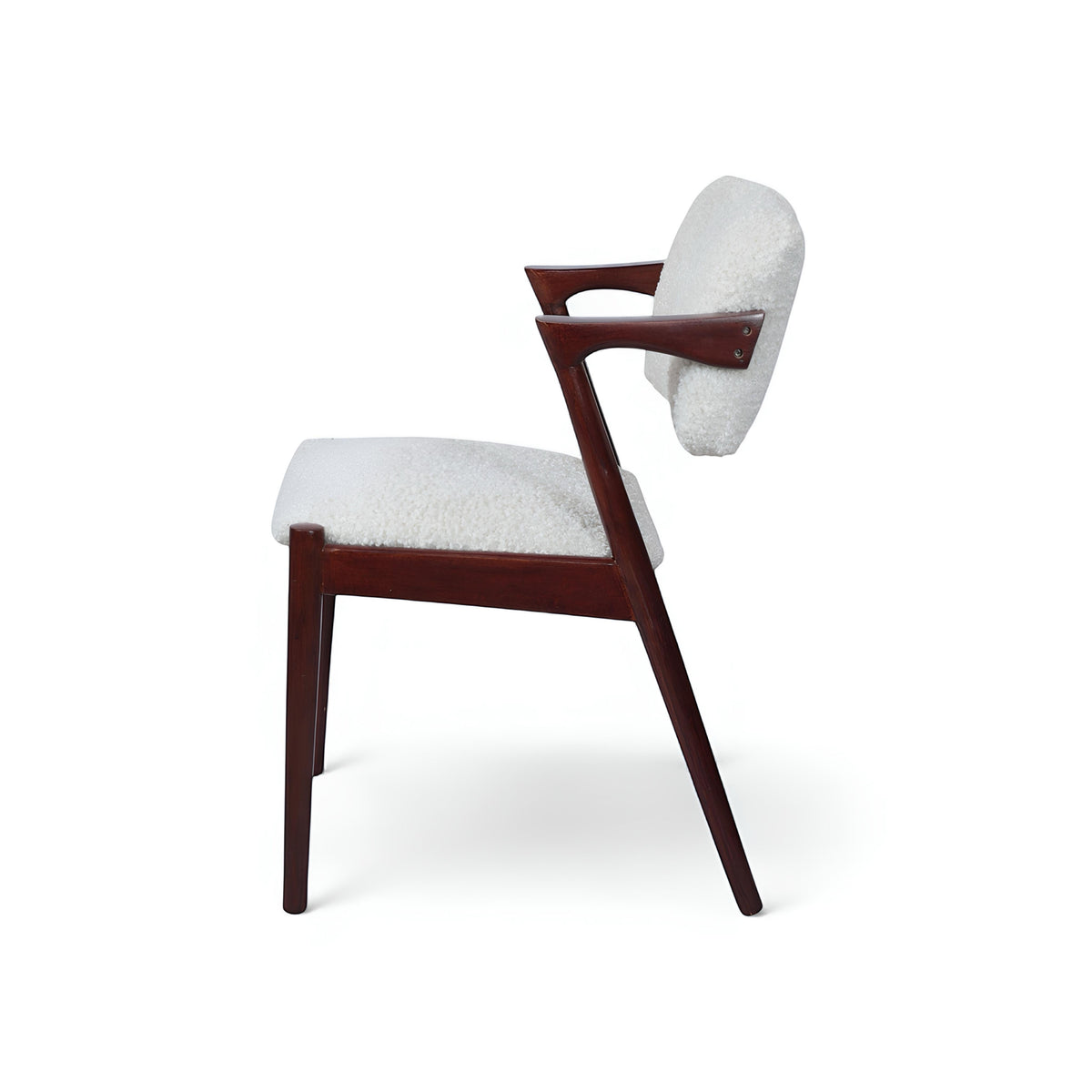 Front angled view of the Vaya Home Angolo dining chair with white boucle upholstery, angled wood arms, and a dark wood frame.