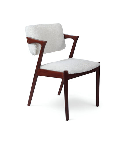 Front view of the Vaya Home Angolo dining chair with white boucle upholstery, sculpted arms, and a dark wood frame.