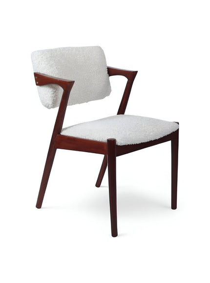 Front view of the Vaya Home Angolo dining chair with white boucle upholstery, sculpted arms, and a dark wood frame.