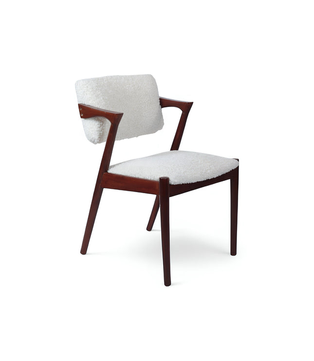 Front view of the Vaya Home Angolo dining chair with white boucle upholstery, sculpted arms, and a dark wood frame.