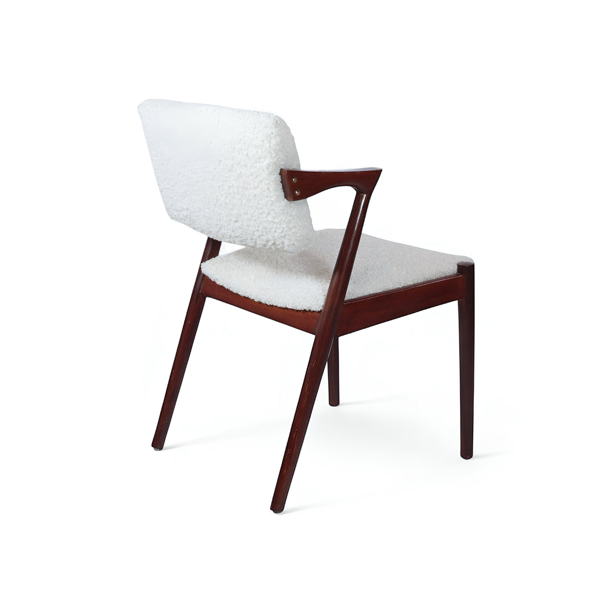 Rear angled view of the Vaya Home Angolo dining chair featuring white boucle upholstery, angled wood arms, and a dark wood frame.