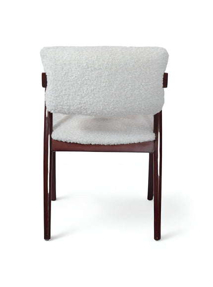 Opposite side view of the Vaya Home Angolo dining chair featuring white boucle upholstery, angled wood arms, and a dark wood frame.