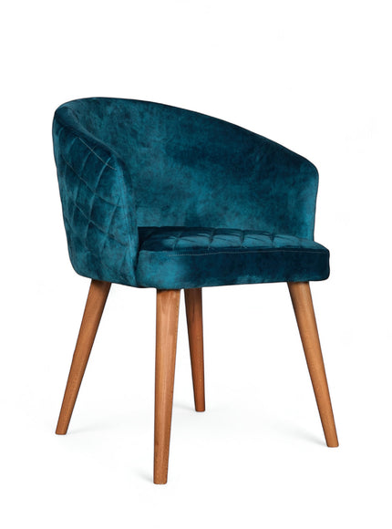 Front angled view of the Vaya Home Antigo dining chair with blue velvet upholstery, curved barrel back, and tapered wood legs.