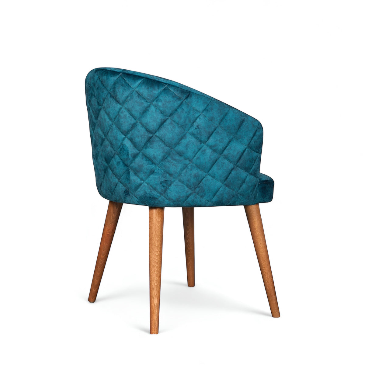 Rear angled view of the Vaya Home Antigo dining chair featuring blue velvet upholstery, diamond-quilted back detail, and tapered wood legs.