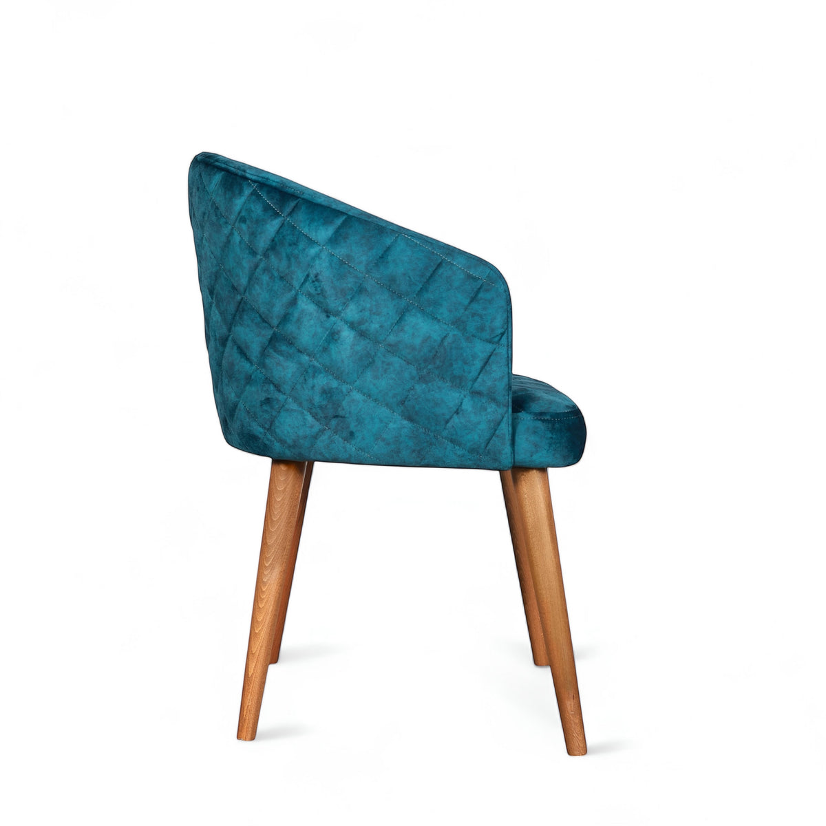 Side view of the Vaya Home Antigo dining chair with blue velvet upholstery, quilted outer back, and tapered wood legs.