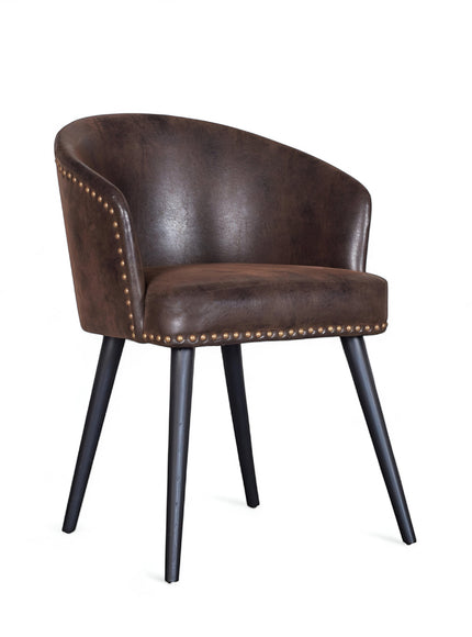 Front angled view of the Vaya Home Antigo dining chair with dark brown leather upholstery, nailhead trim, and black tapered legs.