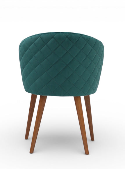 Back view of the Vaya Home Antigo dining chair featuring green velvet upholstery, diamond-quilted back detail, and tapered wood legs.
