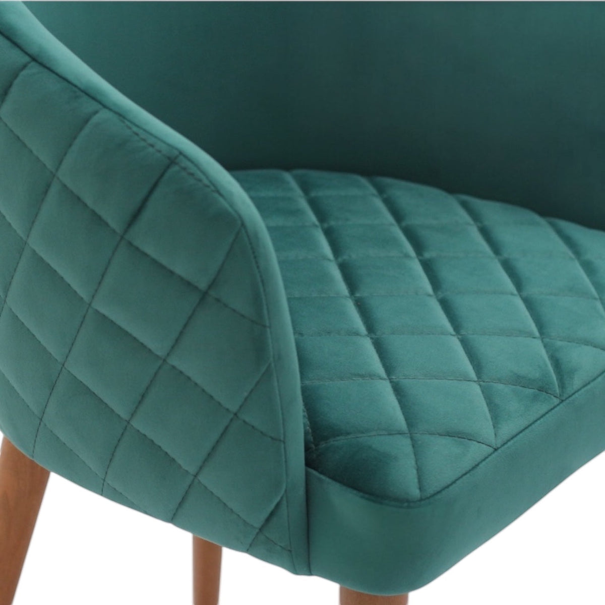 Close-up of the Vaya Home Antigo dining chair showing green velvet upholstery and diamond-quilted seat and back detail.