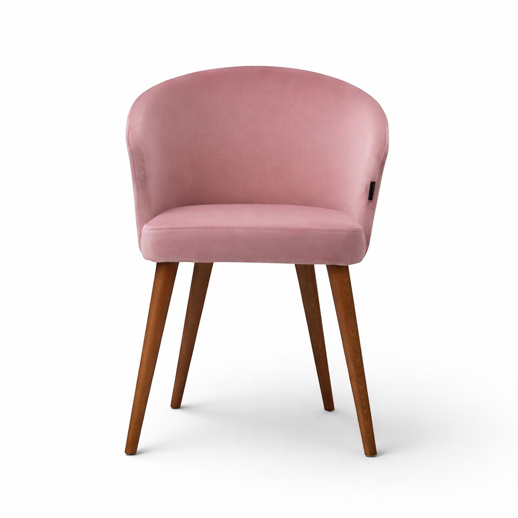 Front view of the Vaya Home Antigo dining chair with pink velvet upholstery, rounded barrel back, and tapered wood legs.