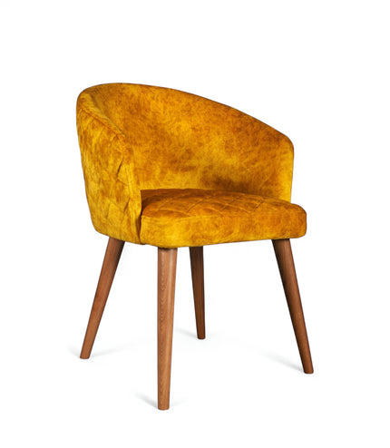 Front angled view of the Vaya Home Antigo dining chair with yellow velvet upholstery, curved barrel back, and tapered wood legs.