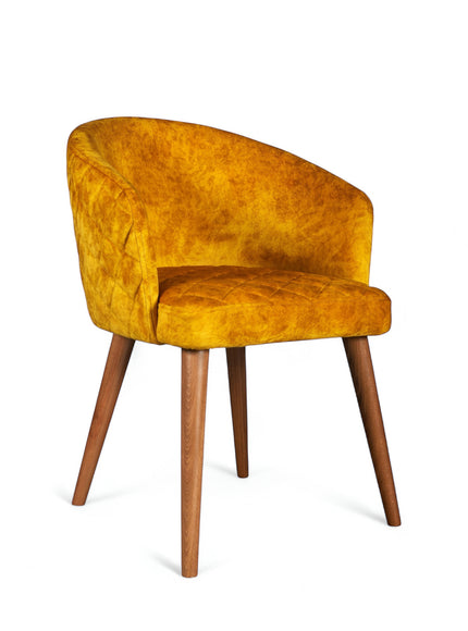 Front angled view of the Vaya Home Antigo dining chair with yellow velvet upholstery, curved barrel back, and tapered wood legs.