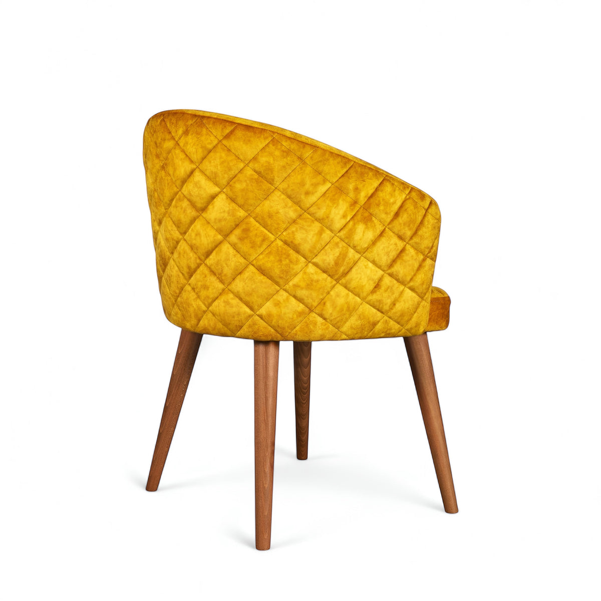 Rear angled view of the Vaya Home Antigo dining chair featuring yellow velvet upholstery, diamond-quilted back detail, and tapered wood legs.