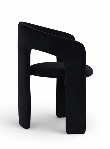 Side view of the Vaya Home Arcadia accent chair showing its sculptural curved frame, cutout arm detail, and black upholstered seat.
