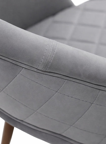 Close-up of the Vaya Home Argent dining chair showing grey upholstery, quilted stitching, and curved backrest detail.