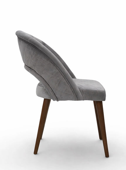 Side view of the Vaya Home Argent dining chair showing its curved open backrest, upholstered seat, and wood legs.