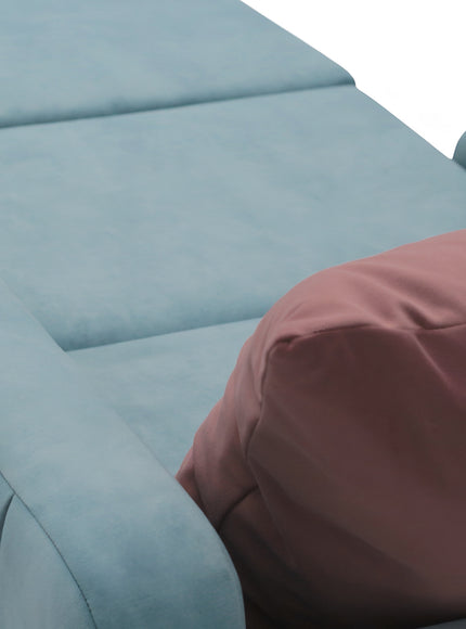 Close-up of the Vaya Home Aristo chair bed showing blue upholstery and pink accent cushion detail.