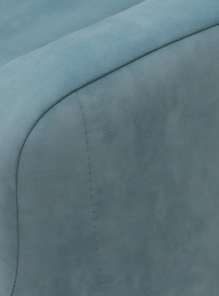Close-up of the Vaya Home Aristo chair bed showing blue upholstery and seam detailing on the armrest.