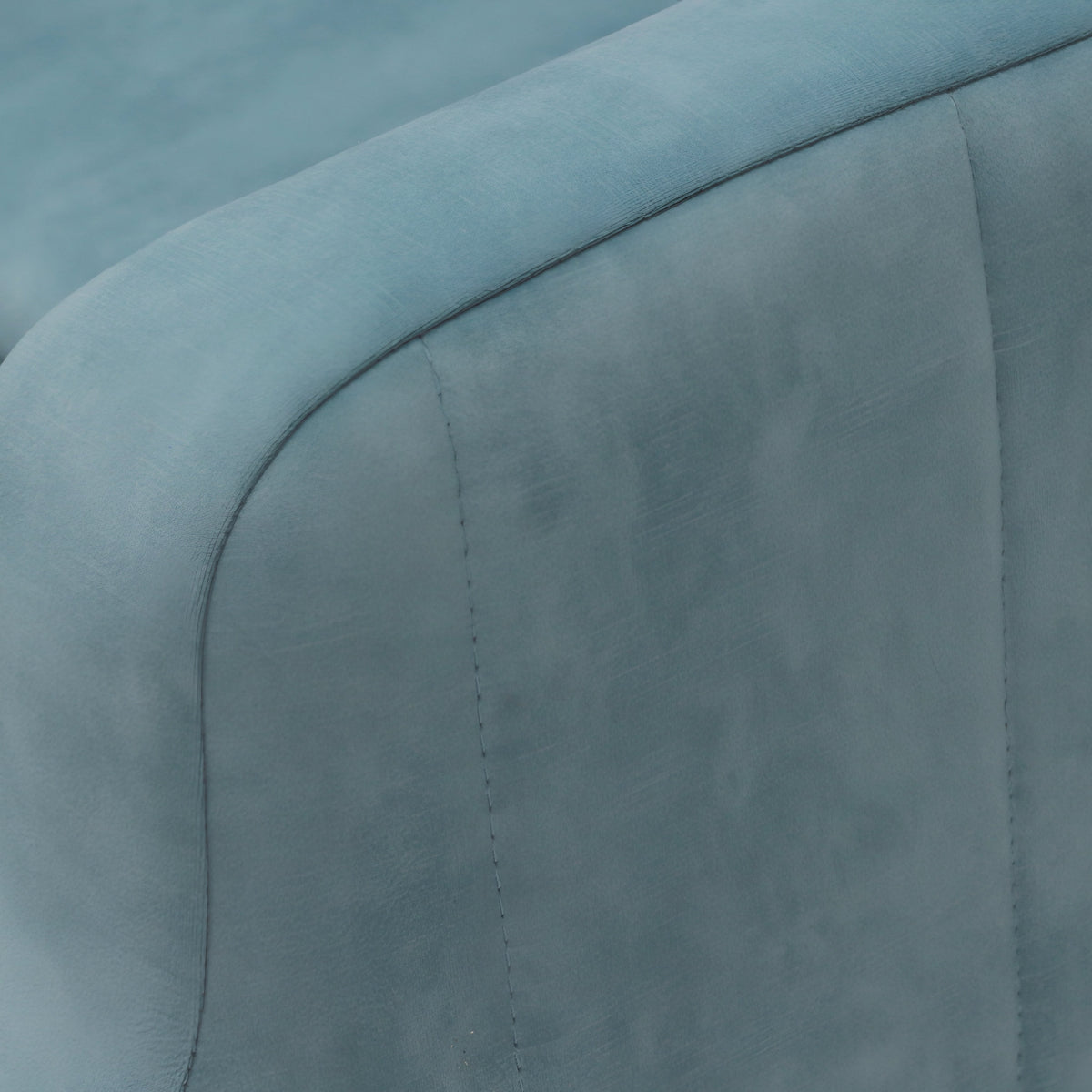 Close-up of the Vaya Home Aristo chair bed showing blue upholstery and seam detailing on the armrest.