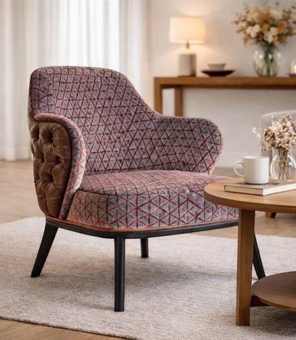 Vaya Home Array accent chair with geometric patterned upholstery, tufted brown leather outer back, and black legs, styled in a modern living room.