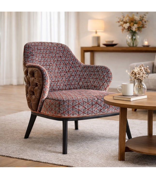 Vaya Home Array accent chair with geometric patterned upholstery, tufted brown leather outer back, and black legs, styled in a modern living room.