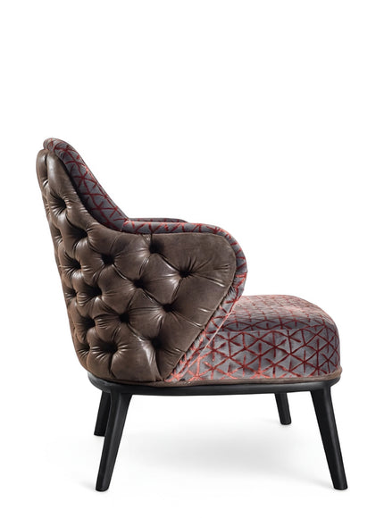 Side view of the Vaya Home Array accent chair showing tufted brown leather side panels, geometric patterned upholstery, and black legs.