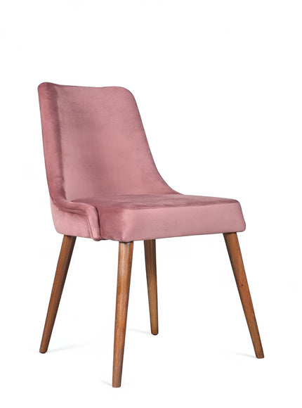 Front angled view of the Vaya Home Arrossire dining chair with pink velvet upholstery, cushioned seat, and tapered wood legs.