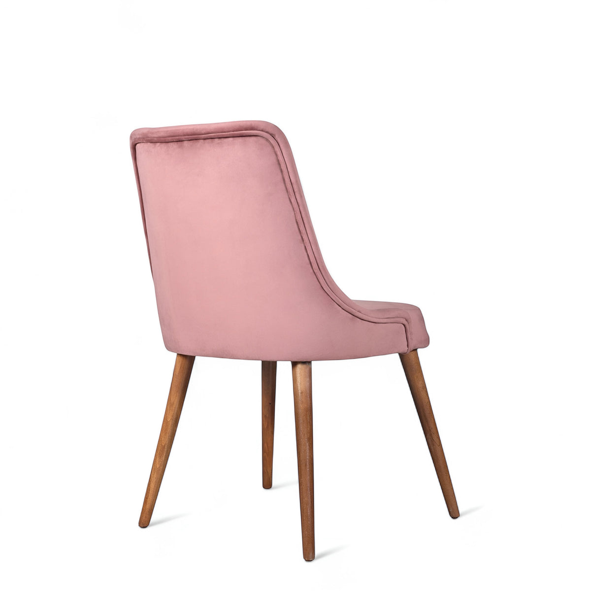 Rear angled view of the Vaya Home Arrossire dining chair featuring pink velvet upholstery, a softly curved backrest, and tapered wood legs.