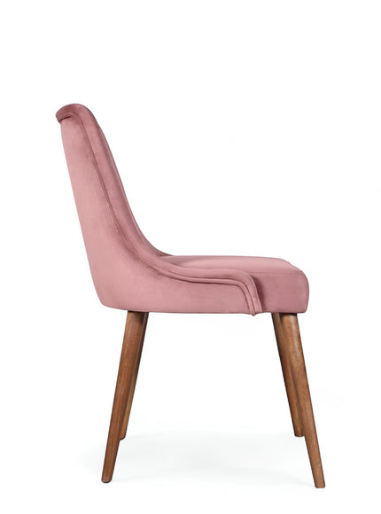 Side view of the Vaya Home Arrossire dining chair with pink velvet upholstery, slim profile, and tapered wood legs.