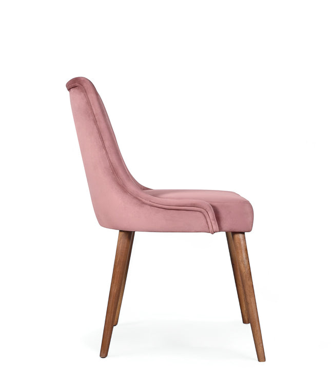 Side view of the Vaya Home Arrossire dining chair with pink velvet upholstery, slim profile, and tapered wood legs.