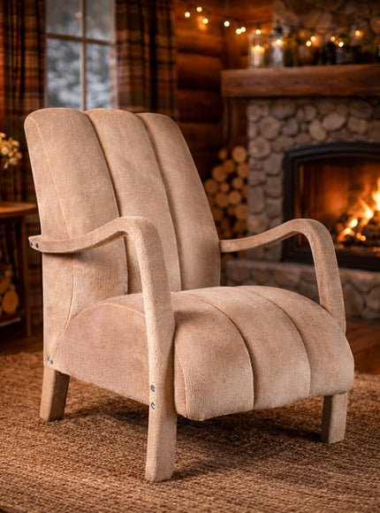Vaya Home Aura accent chair in beige upholstery with curved wood arms and a channel-tufted back, styled in a cozy fireside room.