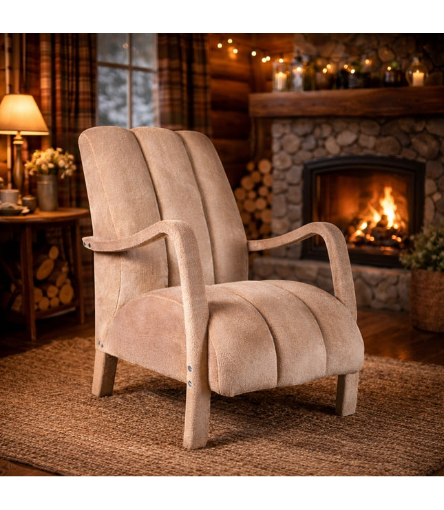 Vaya Home Aura accent chair in beige upholstery with curved wood arms and a channel-tufted back, styled in a cozy fireside room.