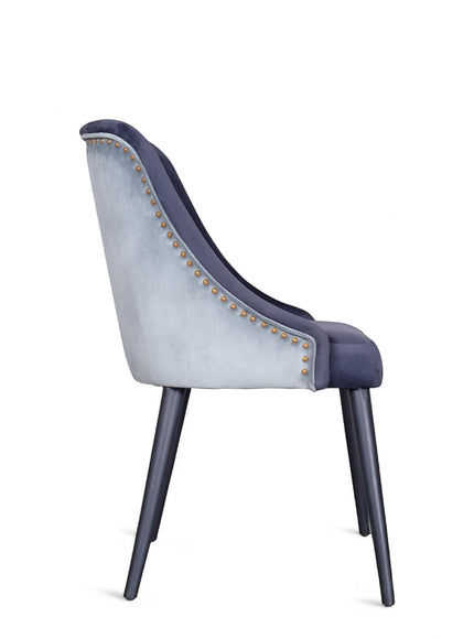 Rear angled view of the Vaya Home Azzurro dining chair featuring dark blue upholstery, contrast trim detail, and tapered dark legs.