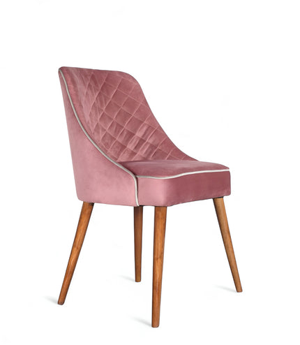 Front angled view of the Vaya Home Azzurro dining chair with pink upholstery, quilted back detail, and tapered wood legs.