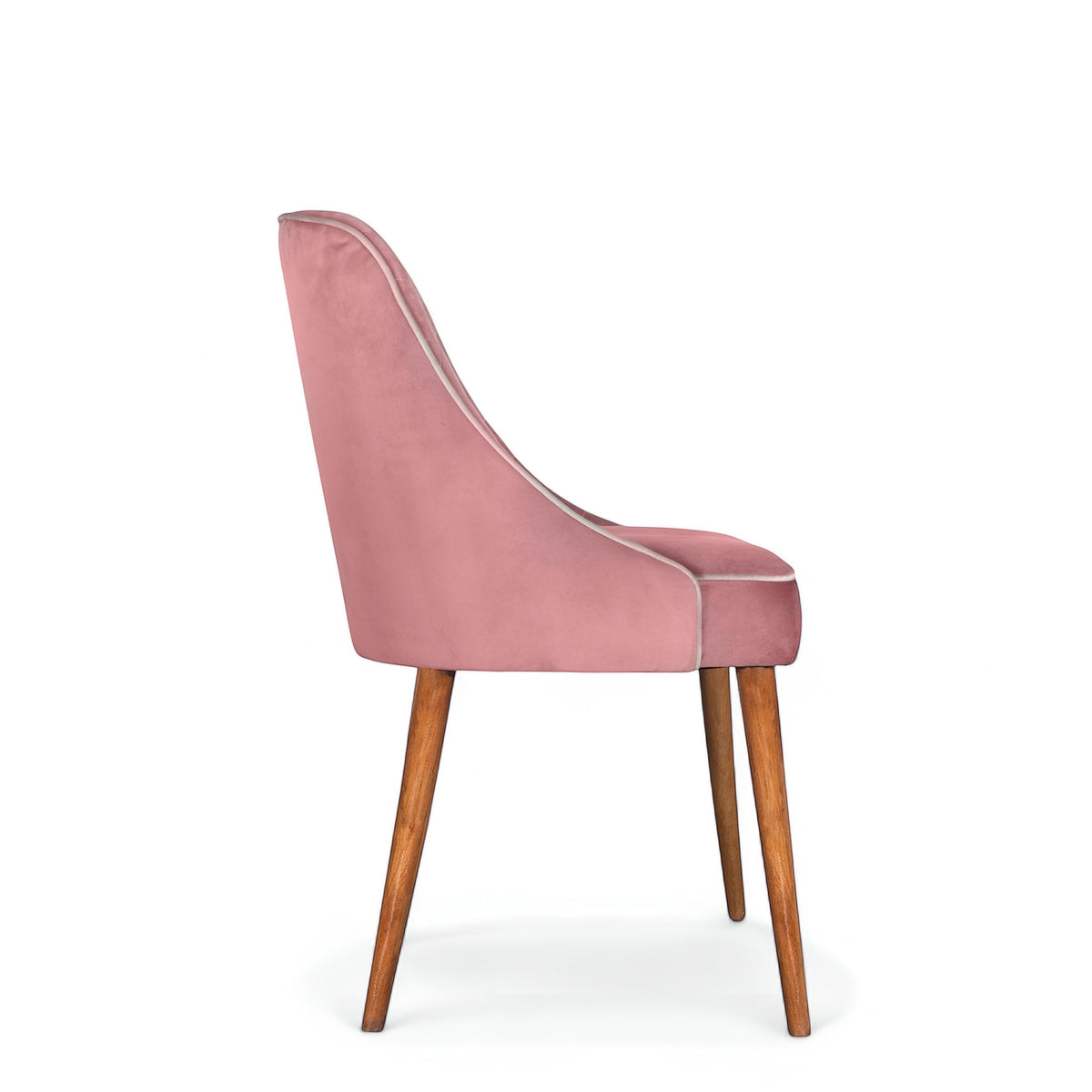 Rear angled view of the Vaya Home Azzurro dining chair featuring pink upholstery, a softly curved backrest, and tapered wood legs.