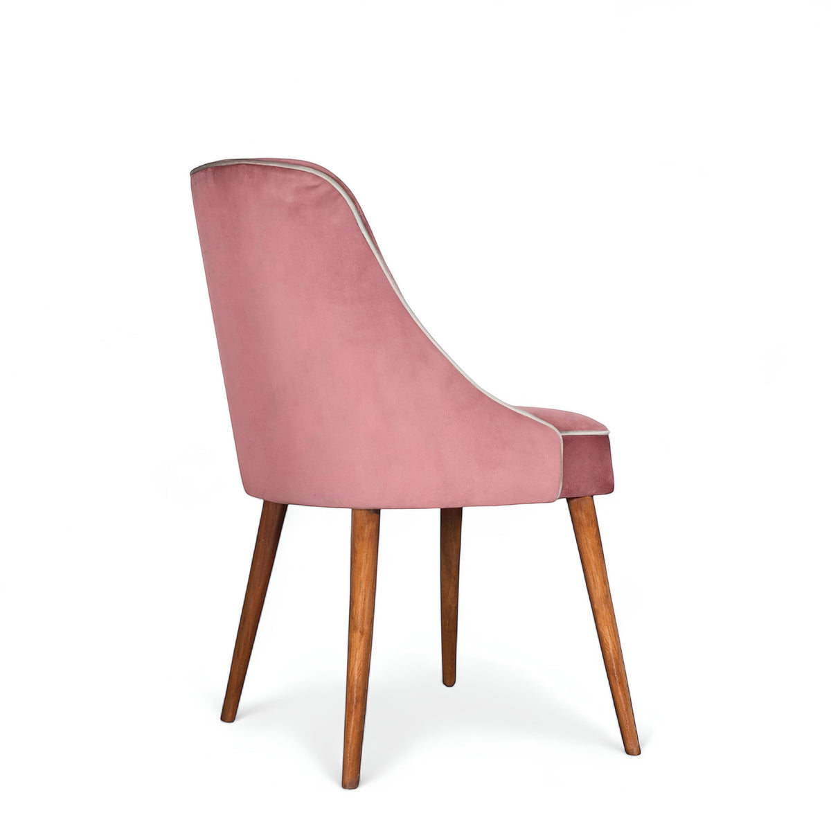 Side view of the Vaya Home Azzurro dining chair with pink upholstery and tapered wood legs.