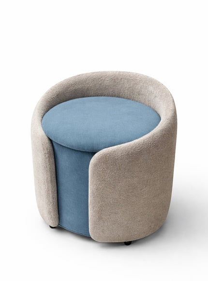 Vaya Home Barrel round storage ottoman with blue seat cushion and cream upholstered exterior.