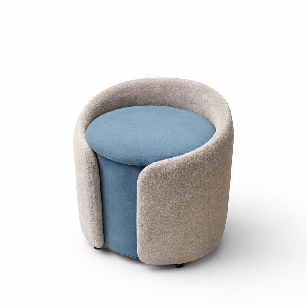 Vaya Home Barrel round storage ottoman with blue seat cushion and cream upholstered exterior.