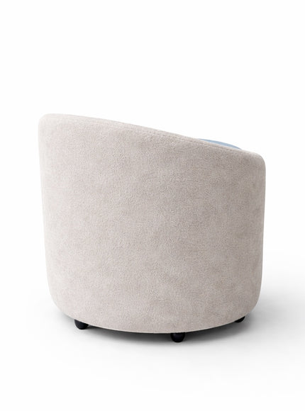 Back view of the Vaya Home Barrel round storage ottoman in light cream upholstery.