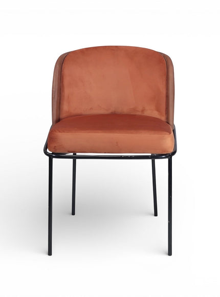 Front view of the Vaya Home Batata dining chair featuring brown upholstery, rounded backrest, and slim black metal legs.