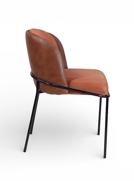 Side view of the Vaya Home Batata dining chair featuring brown upholstery, a curved backrest, and slim black metal legs.
