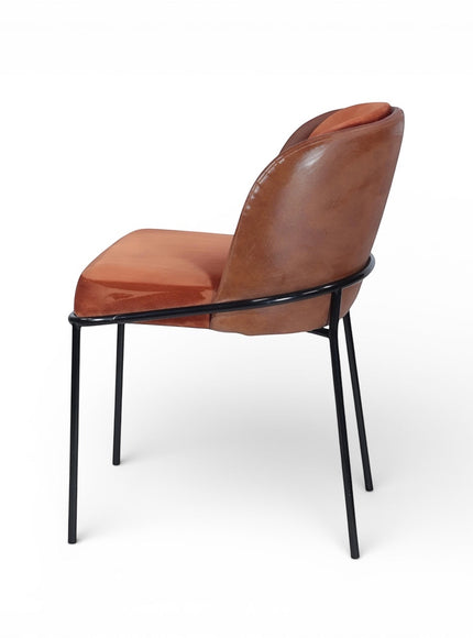Opposite side view of the Vaya Home Batata dining chair with brown upholstery, curved backrest, and slim black metal legs.