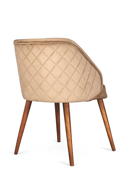 Rear angled view of the Vaya Home Biscotta dining chair featuring beige upholstery, diamond-quilted back detail, and tapered wood legs.