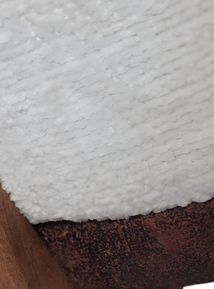 Close-up of the Vaya Home Cadena dining chair showing white boucle upholstery and wood frame detail.